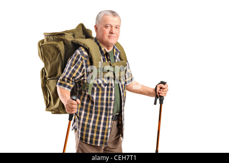 A smiling mature avec sac à dos holding bâtons posant isolé sur fond blanc Banque D'Images