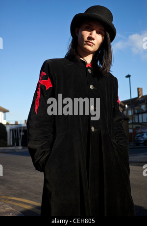 Portrait d'un jeune homme portant Goth long manteau noir et un chapeau, London, England, UK Banque D'Images