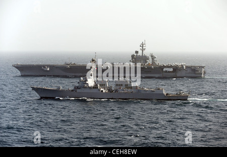 Le destroyer de missiles guidés de classe Arleigh Burke USS Momsen se rapproche du porte-avions de classe Nimitz USS Carl Vinson. Carl Vinson et Carrier Air Wing (CVW) 17 sont déployés dans la zone de responsabilité de la 5e flotte américaine. Banque D'Images