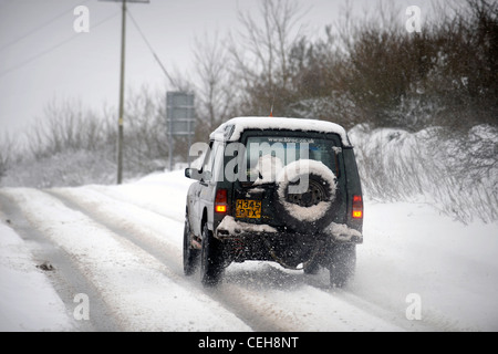 Un Land Rover 4x4 négocie une colline dans la neige dans le Gloucestershire UK Banque D'Images