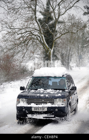 Une Range Rover 4x4 négocie une colline dans la neige dans le Gloucestershire UK Banque D'Images