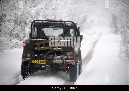 Une Land Rover jeep 4x4 sur une voie dans la neige dans le Gloucestershire UK Banque D'Images