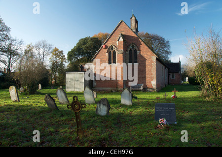 L'église en brique rouge peu étrange de l'Ascension, et c'est cimetière, dans le village de Dorset de Woodlands. Angleterre, Royaume-Uni. Banque D'Images