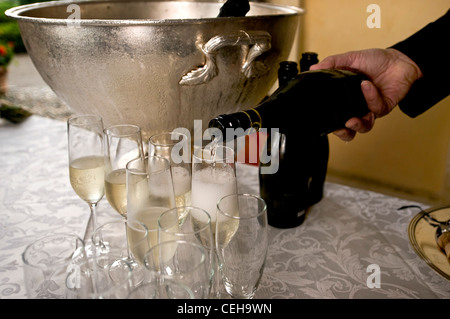 Waiter pouring champagne dans le verre à un mariage apéritif Banque D'Images