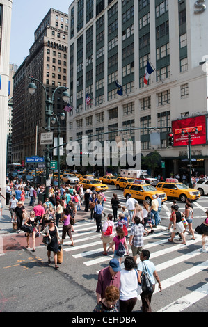 Les piétons traversant road at West 34th Street, New York. sur un passage piéton Banque D'Images