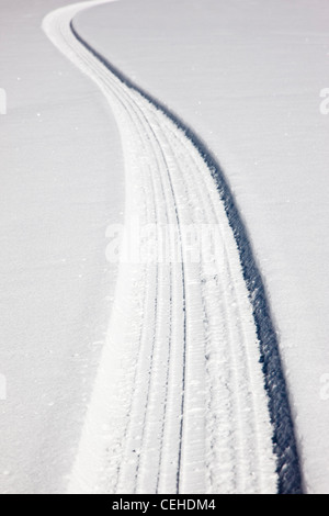 Des traces de pneus sur une route de montagne couverte de neige près de Monarch Pass, Chaffee Comté, Colorado, USA Banque D'Images