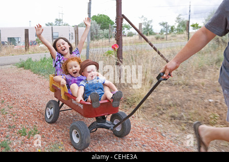 Trois enfants d'être tiré dans un wagon, des cris d'excitation. Banque D'Images