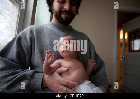 Père tenant son bébé nouveau-né fille à la maison. Banque D'Images