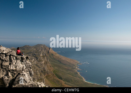 Hiker resting on rock lookout surplombant la ville du Cap, Table Mountain, Province de Western Cape Banque D'Images