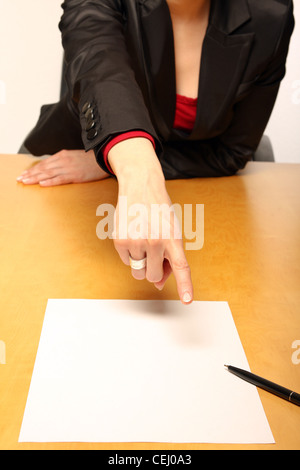 Vue d'une femme assise au bureau en face de papier vierge et gesturing Banque D'Images