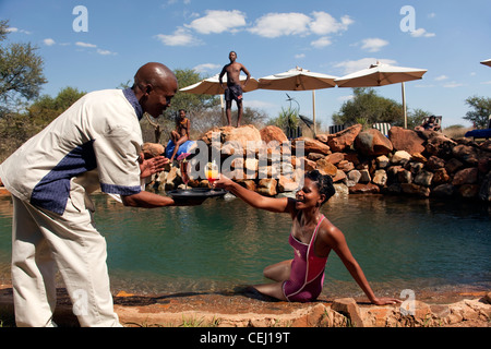 Waiter serving'cocktails au bord de la piscine,Madikwe Game Lodge, North West Province Banque D'Images