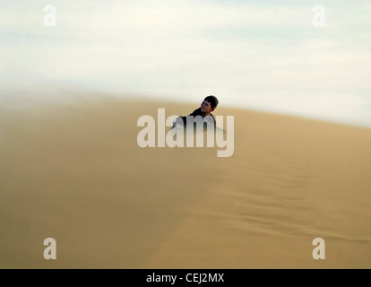 Un enfant sur les dunes de sable du désert dans une tempête Banque D'Images