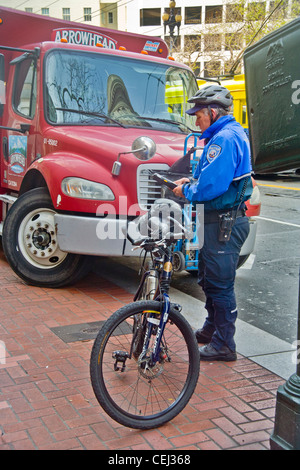 À l'aide d'un ordinateur sans fil, un parking vélo canada préfet écrit une contravention pour un camion en stationnement illégal Banque D'Images