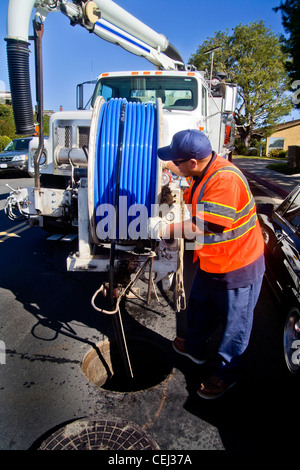 À l'aide d'un système d'aspiration monté sur camion, un technicien nettoie un égout bouché à Laguna Niguel, CA Banque D'Images