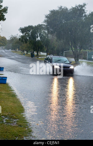 Route inondée avec voiture rouler dans l'eau Banque D'Images