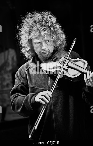 Un portrait en noir et blanc d'un homme blanc de 30 à 35 ans aux spectacles de rue,la lecture d'un violon sur les rues de Londres. Banque D'Images