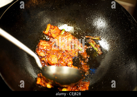Chef de remuer la friture dans un wok dans un restaurant coréen. Banque D'Images