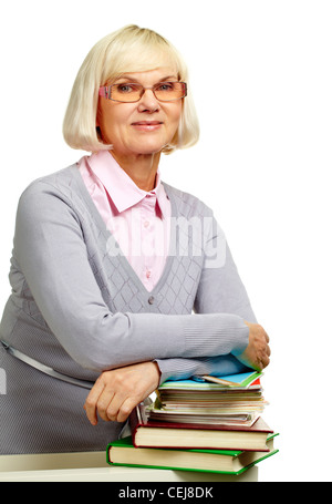 Jolie femme âgée, penché sur une pile de livres isolé sur fond blanc Banque D'Images