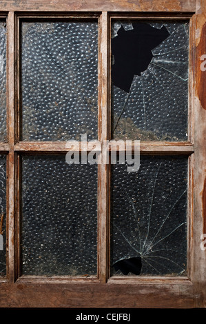 Une ancienne fenêtre avec deux de ses volets broken Banque D'Images