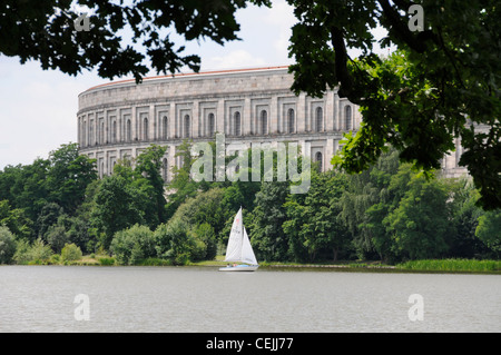 De l'autre côté d'un grand lac, se trouvent les imposants vestiges de la salle des congrès (Die Kongresshalle) dans l'ancien site de rassemblement nazi de Nuremberg, en Bavière, en Allemagne. Banque D'Images