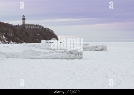 Piers congelés et surgelés, de la mer Baltique en Niechorze, Pologne. Dans l'arrière-plan vous pouvez voir le phare. Banque D'Images