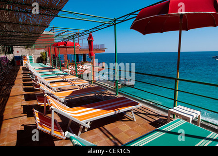 Des chaises longues avec parasol sur la terrasse donnant sur la mer, Capri, italie Banque D'Images