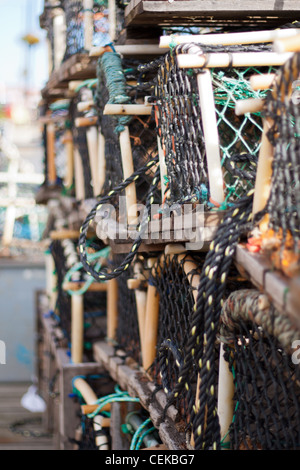 Le homard, le crabe et les filets de pêche et de pots vides empilées et prêt à être utilisé par les pêcheurs de l'industrie de la pêche. Banque D'Images