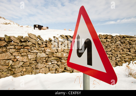 Un panneau routier sur la puce dans la neige, Lake District, UK. Banque D'Images