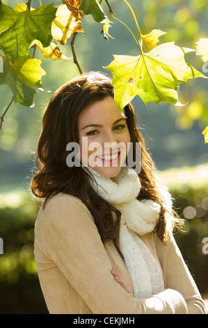 Porter femme veste beige et crème écharpe en Arbre avec bras croisés Banque D'Images