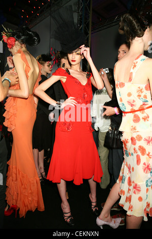 John Galliano Printemps Été Paris Backstage Model wearing red dress sequins rouge et noir, grand chapeau noir, noir de compensation Banque D'Images