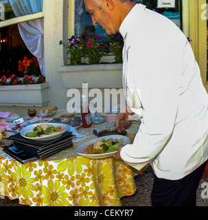 Paris, France - Homme serveur français, servant dans le restaurant français classique, "Le Châlet des Iles', Terrasse Banque D'Images