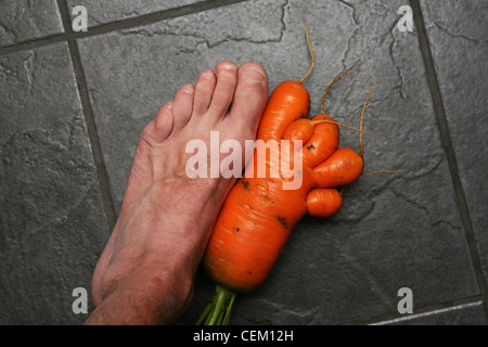 Un accueil en forme de pied à côté de la carotte cultivée un vrai pied. Banque D'Images