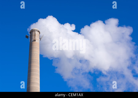 Cheminée industrielle ou gaz émettant des cheminées visible contre le ciel bleu Banque D'Images