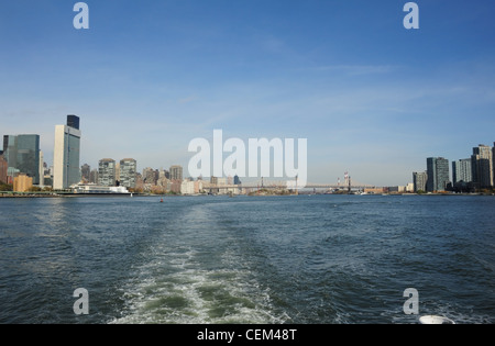 Vue du ciel bleu, à partir de la poupe bateau de croisière Circle Line, les eaux bleues de la rivière de l'Est, au sud de Queensboro Bridge et le bâtiment DES NATIONS UNIES, New York Banque D'Images
