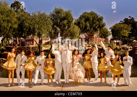 Une jeune fille habillée de façon formelle dans un Cerritos, CA, parc pose pour un photographe avec sa "cour d'honneur composée de filles et garçons. Banque D'Images