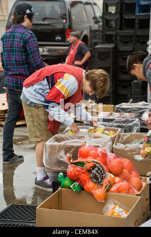 Les bénévoles de bienfaisance de la classe moyenne hauteur en fournissant la nourriture à Costa Mesa, CA, soupe populaire pour nourrir les sans-abri. Banque D'Images