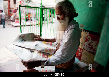 Un Sadhu la lecture de l'actualité Banque D'Images