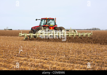 Tracteur Case IH un champ et mettre en oeuvre préparer un champ à la fin du printemps pour la plantation de coton et l'Est de l'Arkansas, USA. Banque D'Images