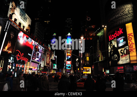 Panneaux néon nuit vue, vers Times Square, un grand nombre de personnes traversant West 46th Street intersection 7th Avenue, New York Banque D'Images