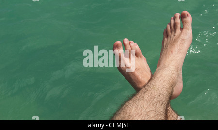 Pieds de détente sur le lac pendant une chaude journée ensoleillée (vacances d'été concept) Banque D'Images