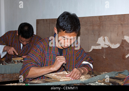 La formation des jeunes de la sculpture sur bois, Institut national des arts et métiers traditionnels Zorig Chusum, Thimphu, Bhoutan Banque D'Images