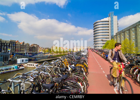 Le cycliste à la recherche d'un endroit pour stationner son vélo près de la gare centrale d'Amsterdam Pays-Bas Hollande eu Europe Banque D'Images