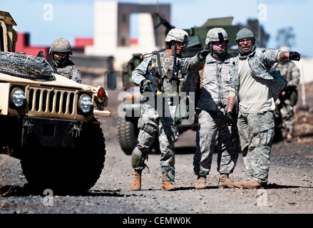 ZONE D'ENTRAÎNEMENT POHAKULOA, Hawaii -- UN soldat de la 57e compagnie de police militaire, 728e Bataillon MP, 8e brigade MP parle avec deux autres soldats jouant des forces opposées sur les lieux où se trouve un suspect recherché lors de l'exercice de terrain de la 57e MP Co., ici, 16 2012 février Banque D'Images