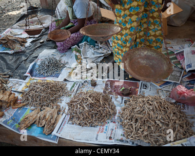 Des tas de poisson séché sur le terrain mis en vente dans les journaux sur le marché de rue avec les commerçants et les échelles Banque D'Images