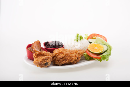 Une assiette de nourriture typique du Costa Rica dans un restaurant ou de soda comprend du poulet frit, de riz, de haricots, de bananes et de la salade. Banque D'Images