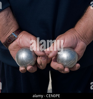 Sciage tenu dans les mains d'un joueur de Pétanque, Close Up, derrière le dos. Banque D'Images