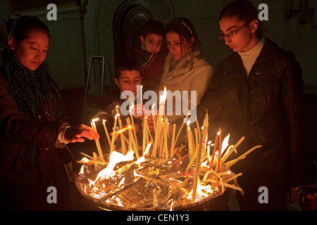 Les chrétiens fidèles allument des bougies dans l'église du Saint-Sépulcre, dans la vieille ville de Jérusalem, Israël. Banque D'Images