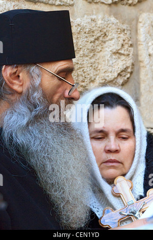 Prêtre grec orthodoxe conduit fidèles en prière dans l'église du Saint-Sépulcre dans la vieille ville de Jérusalem, Israël. Banque D'Images