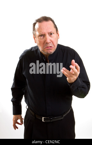 Grumpy Old man dressed in black étend sa main avec un regard de mépris et de colère. Banque D'Images