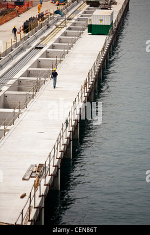 Un travailleur de la construction d'agréables promenades le long de l'waterfromt sur un site de construction à Singapour Banque D'Images